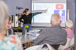 Eine freiwillig engagierte Techniklotsin hält einen Vortrag im Digital-Café. (Quelle: René Ruprecht/MGH)