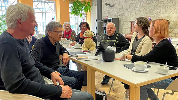 Foto: Peter Schmieder | Das Mehrgenerationenhaus in Haßfurt ist einer von 42 KI-Lernorten. In der Rentenschmiede experimentiert Besucher Werner Burger (Zweiter von links) mit einem Sprachassistenten.